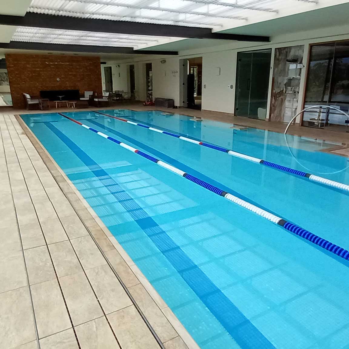 Fully pattern tiled indoor flushdeck lap pool with jacuzzi jets.