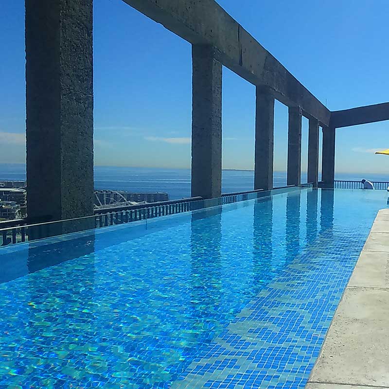 Fully pattern tiled rooftop pool with glass edge, glass wall panel and colour changes floor bubblers.